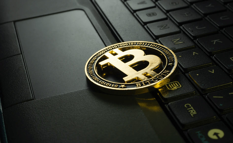 Eine vergoldete Bitcoin-Mnze auf einer Tastatur